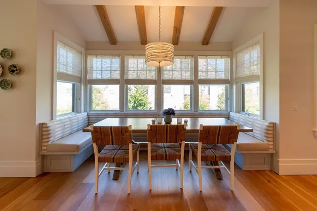 a dining room with furniture large windows and wooden floor