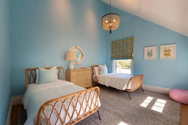 a bedroom with two beds and a chandelier