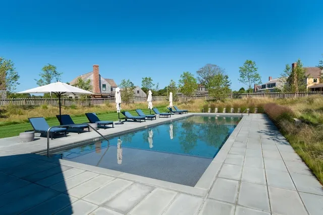 a view of swimming pool with outdoor seating and lake view