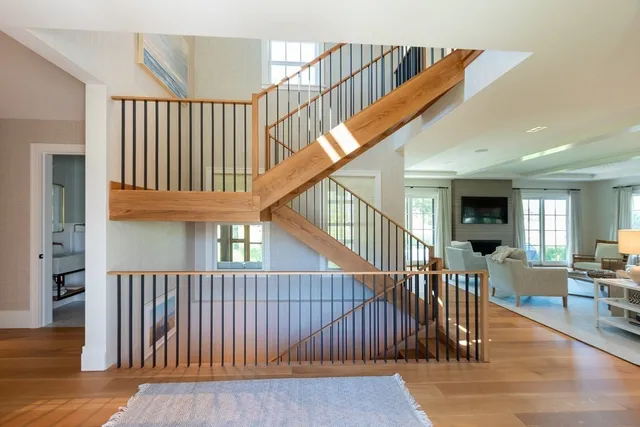 a view of staircase with lots of frames on wall and a baby crib