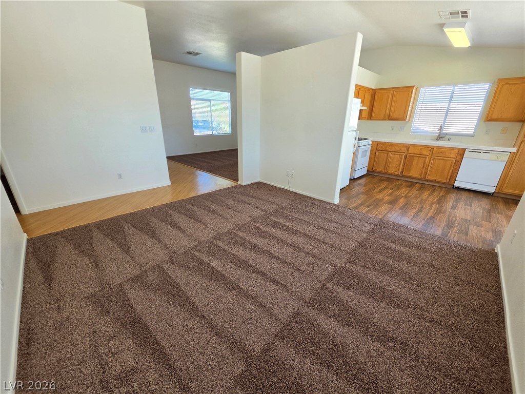 1154 Point Success Avenue Henderson, NV 89014 - Photo 6 of 26 Comfortable living area flows into a functional kitchen with warm wood cabinetry.