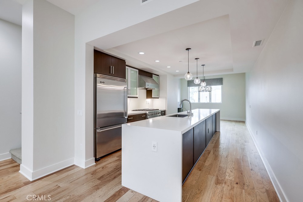 a kitchen with stainless steel appliances a refrigerator and a stove top oven