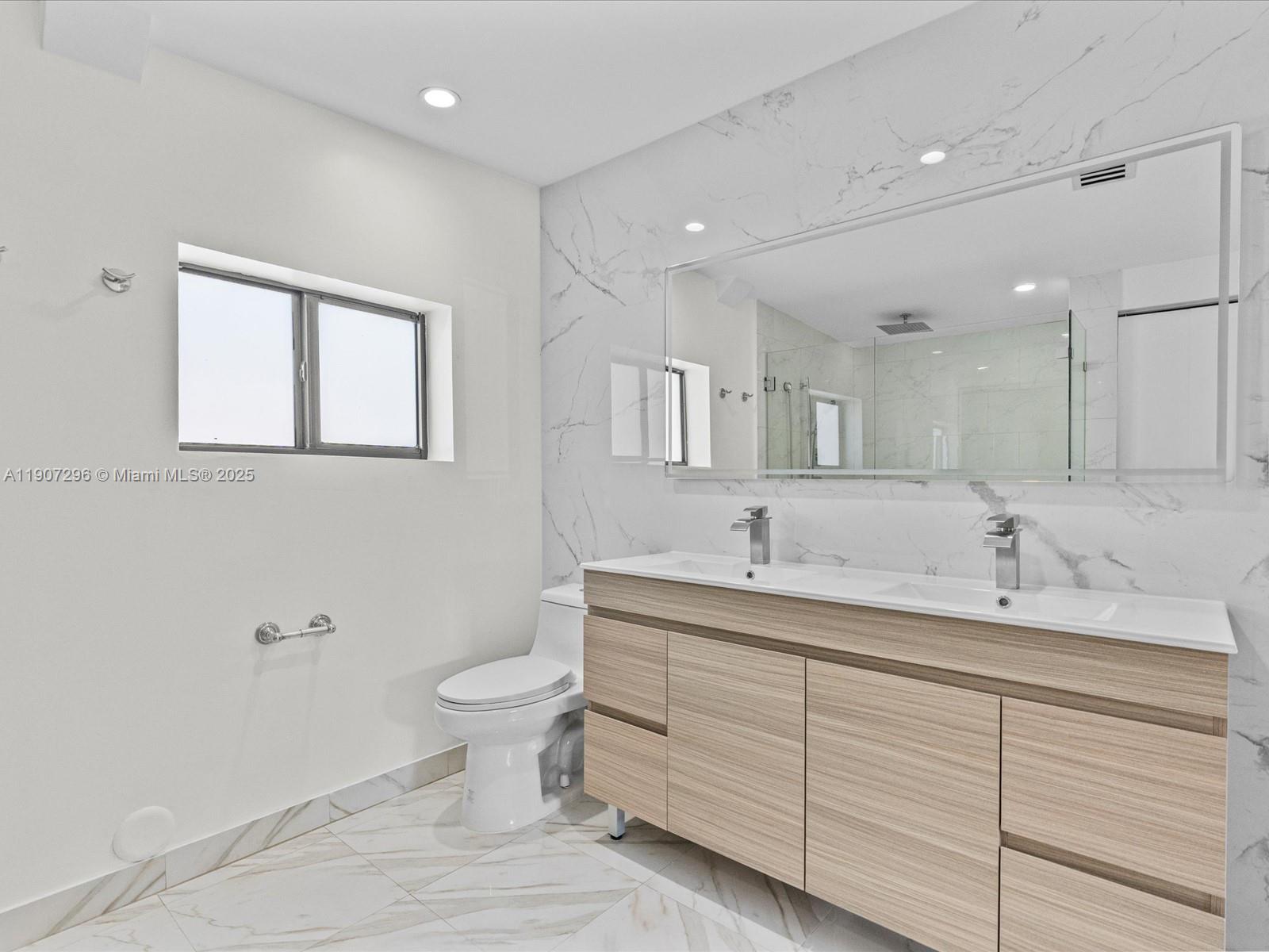 19461 Northeast 22nd Road North Miami Beach, FL 33179 - Photo 15 of 34 a bathroom with a toilet sink and mirror