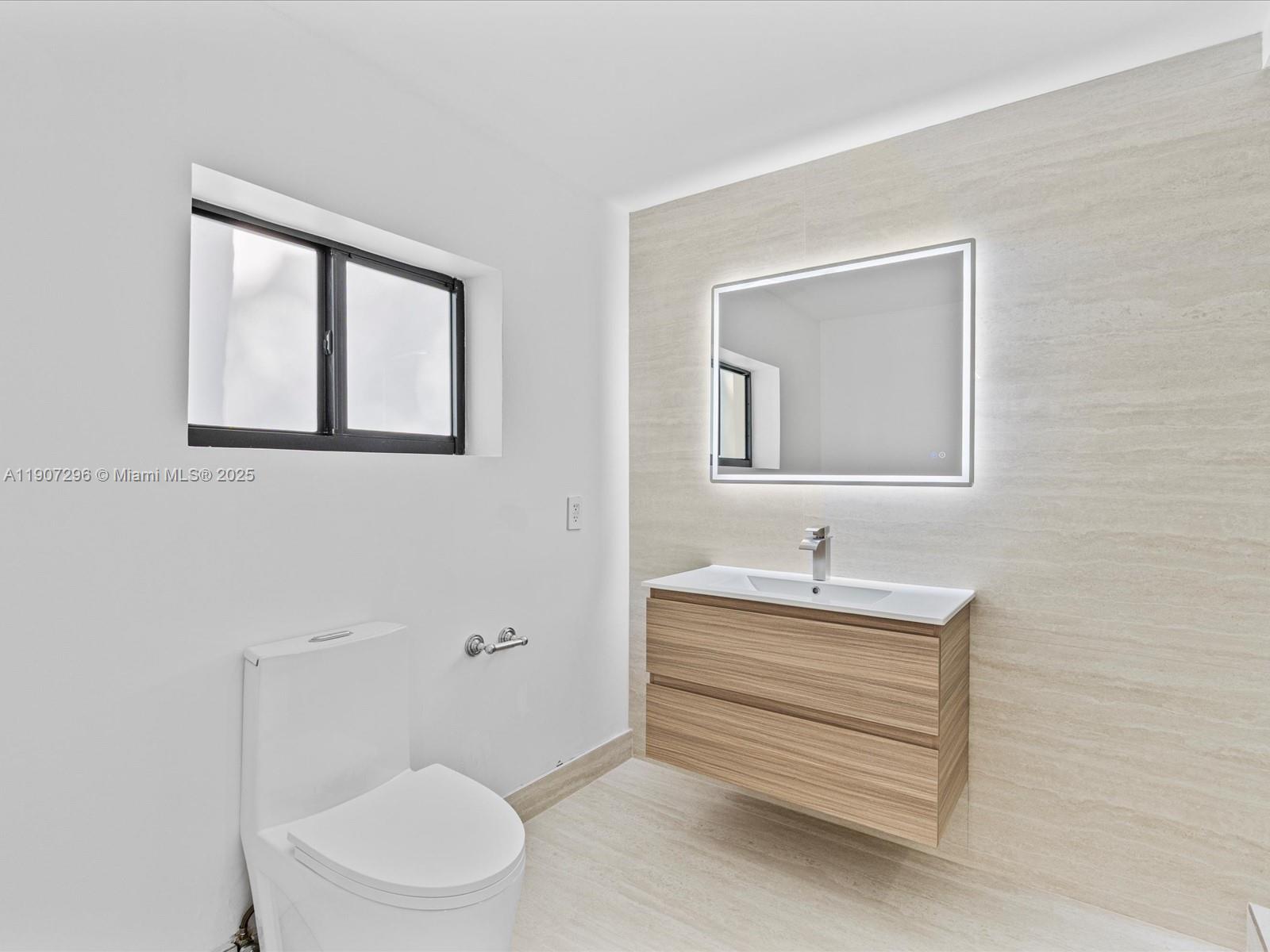 19461 Northeast 22nd Road North Miami Beach, FL 33179 - Photo 18 of 34 a bathroom with a toilet sink and mirror