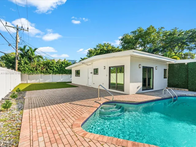 a view of a house with backyard and sitting area