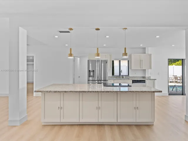 a kitchen with stainless steel appliances granite countertop a sink a stove and a refrigerator