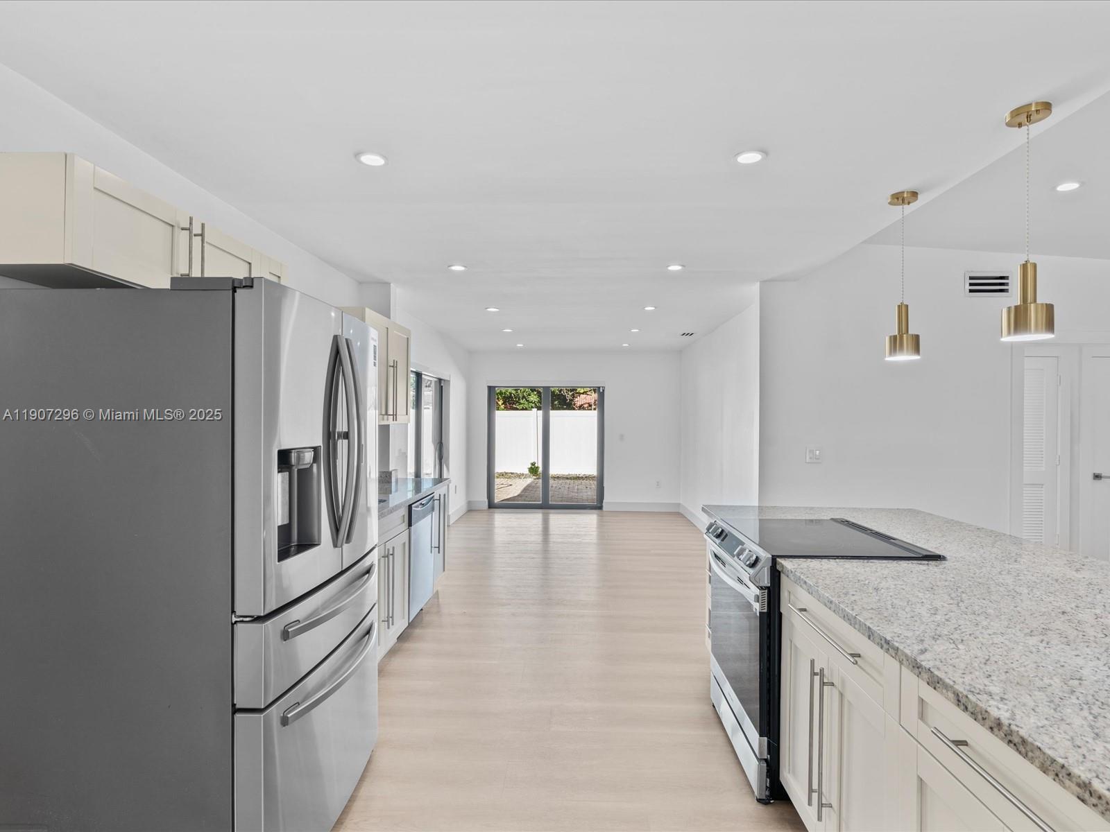 19461 Northeast 22nd Road North Miami Beach, FL 33179 - Photo 10 of 34 a kitchen with granite countertop a refrigerator and a sink