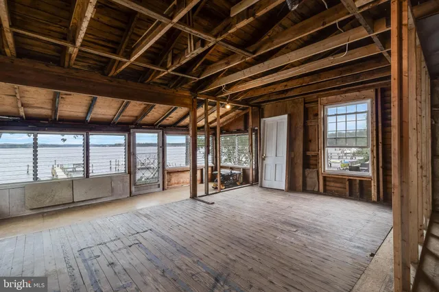a view of an empty room with a fireplace and windows