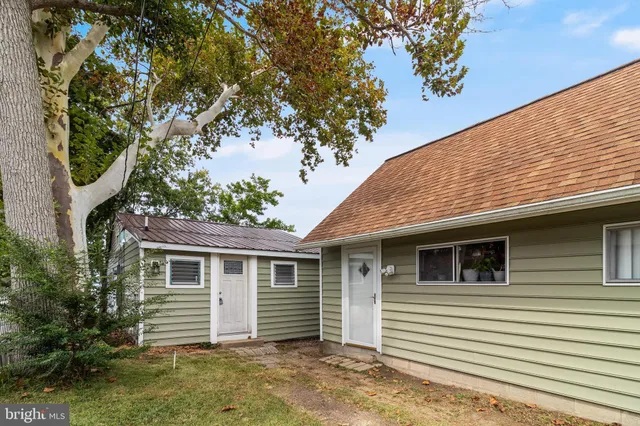 a front view of a house with a tree
