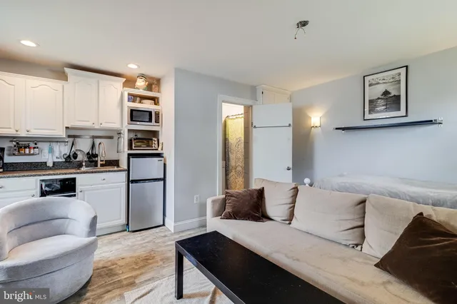 a living room with furniture and kitchen view