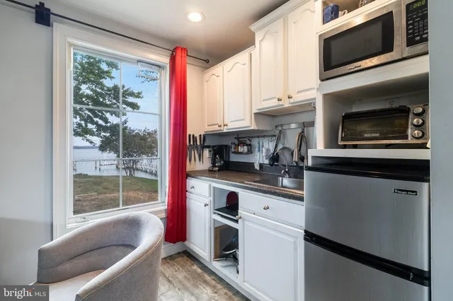 a kitchen with stainless steel appliances a stove microwave and sink