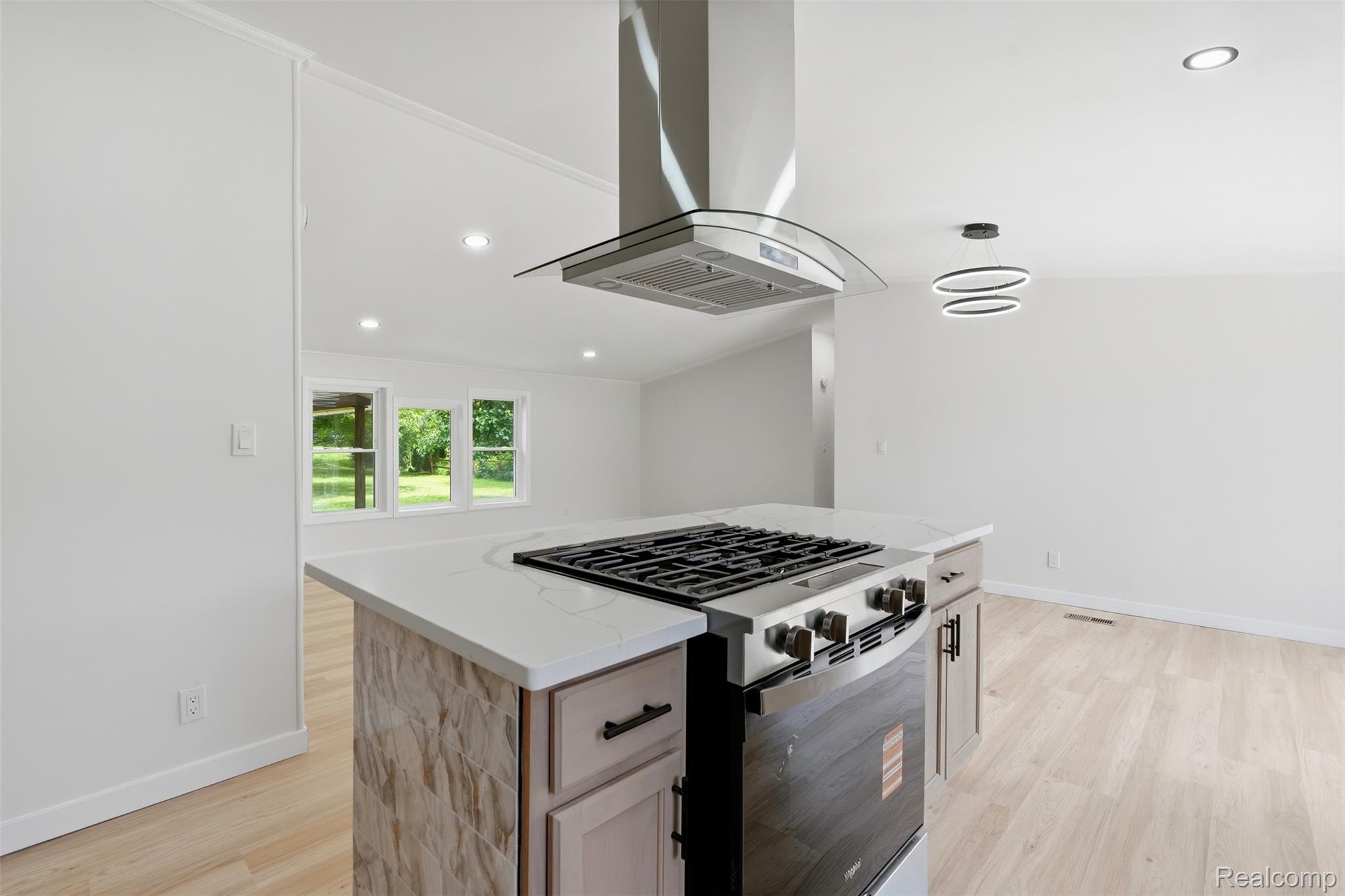 4420 Dublin Road Burton, MI 48529 - Photo 13 of 56 Kitchen island featuring a built-in stainless steel range, white countertop, and integrated storage cabinets