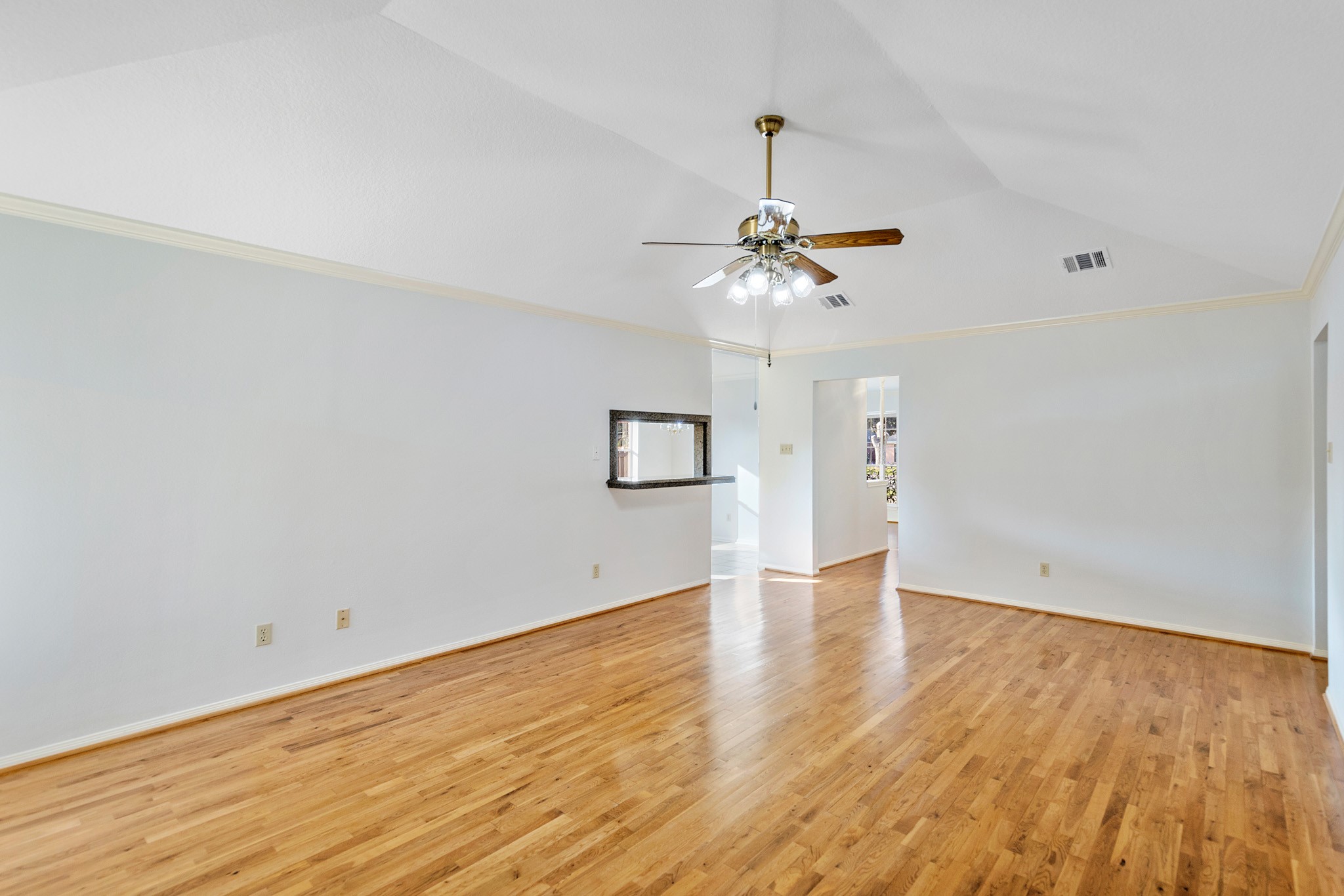 8018 Holiday Lane Houston, TX 77075 - Photo 13 of 42 a view of an empty room with chandelier fan and wooden floor