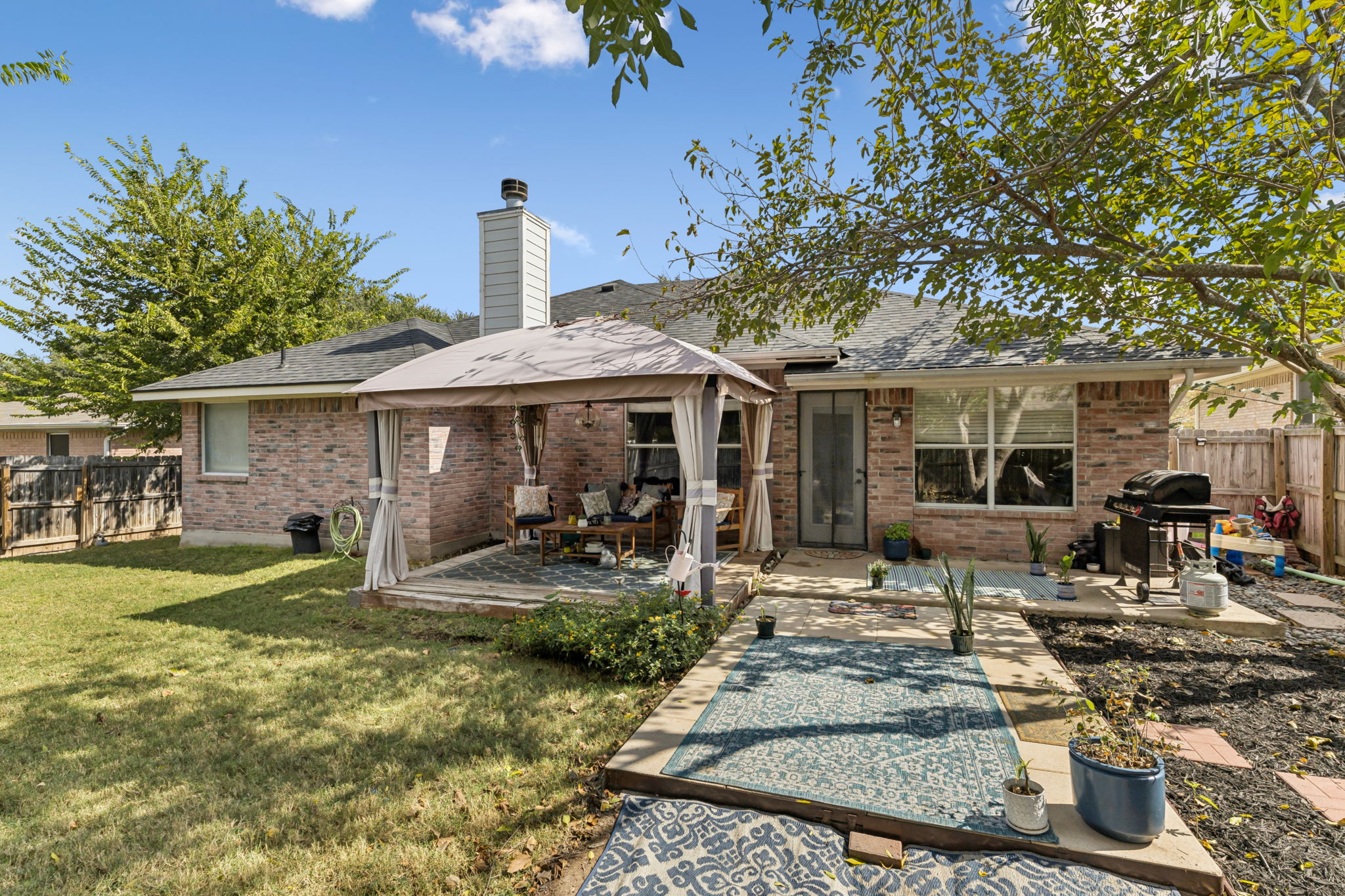 2412 Chestnut Path Round Rock, TX 78664 - Photo 19 of 26 A private backyard oasis awaits, featuring a covered patio area and lush green lawn.