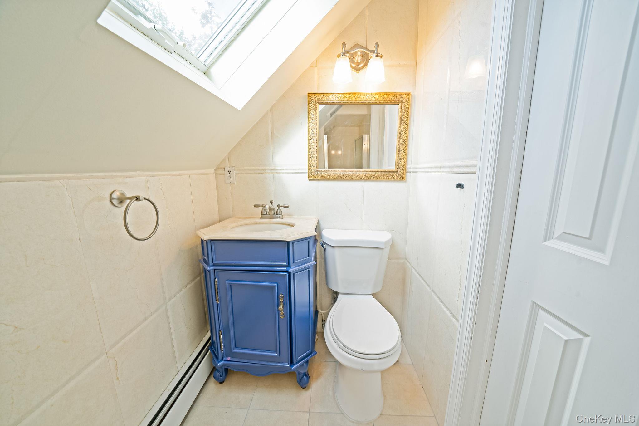 95 Lantern Road Hicksville, NY 11801 - Photo 26 of 36 a bathroom with a toilet a sink a vanity and mirror