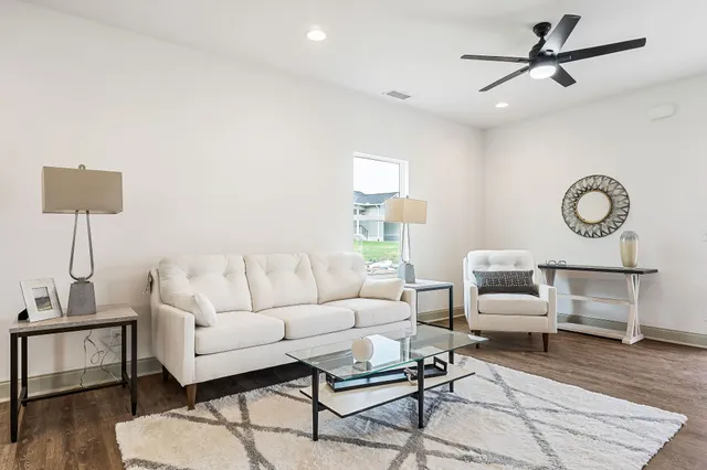 a living room with furniture and a wooden floor