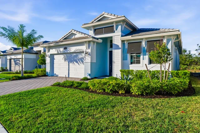 a front view of a house with a garden and plants