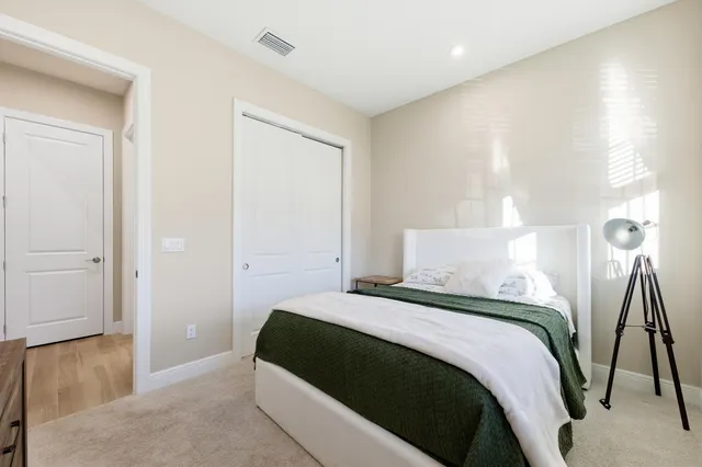 a bedroom with a bed and a wooden floor