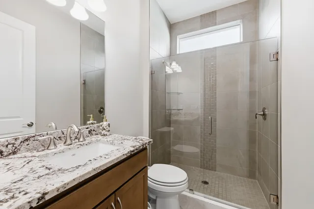 a bathroom with a granite countertop sink toilet and shower