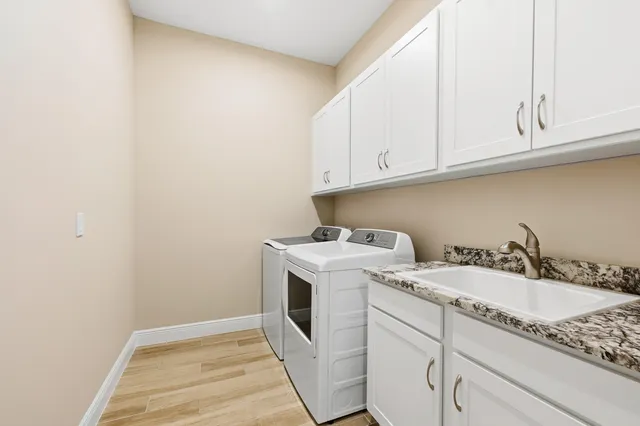 a utility room with sink dryer and washer