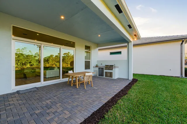 a view of a house with backyard porch and sitting area