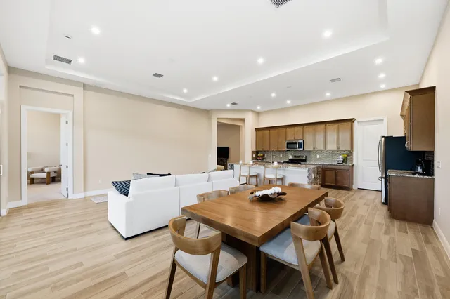 a living room with stainless steel appliances kitchen island granite countertop furniture and wooden floor