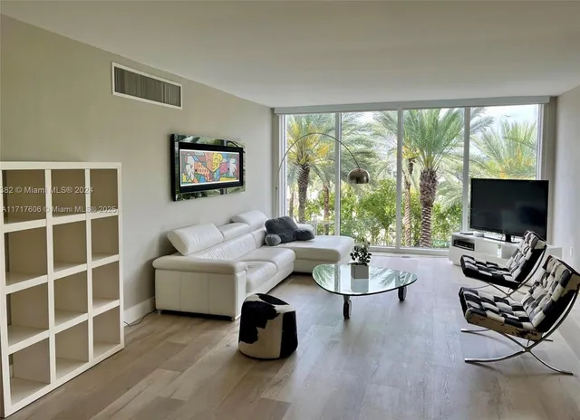 a living room with furniture a flat screen tv and a large window