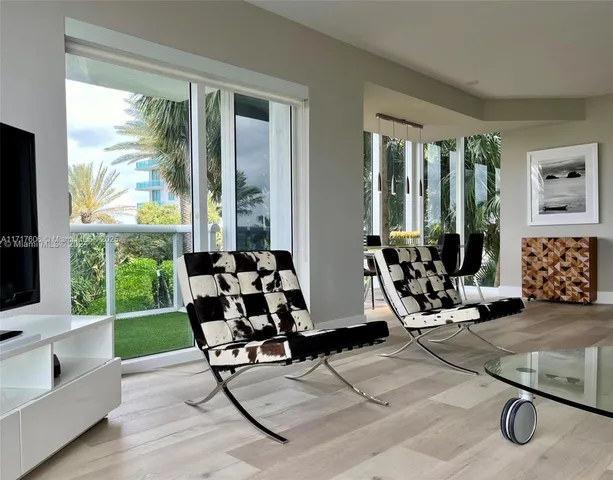 a living room with patio floor to ceiling windows and potted plants