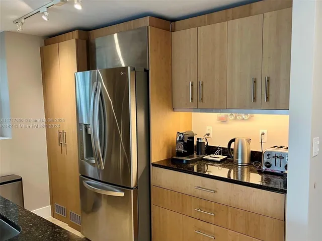 a kitchen with stainless steel appliances granite countertop a refrigerator and a sink