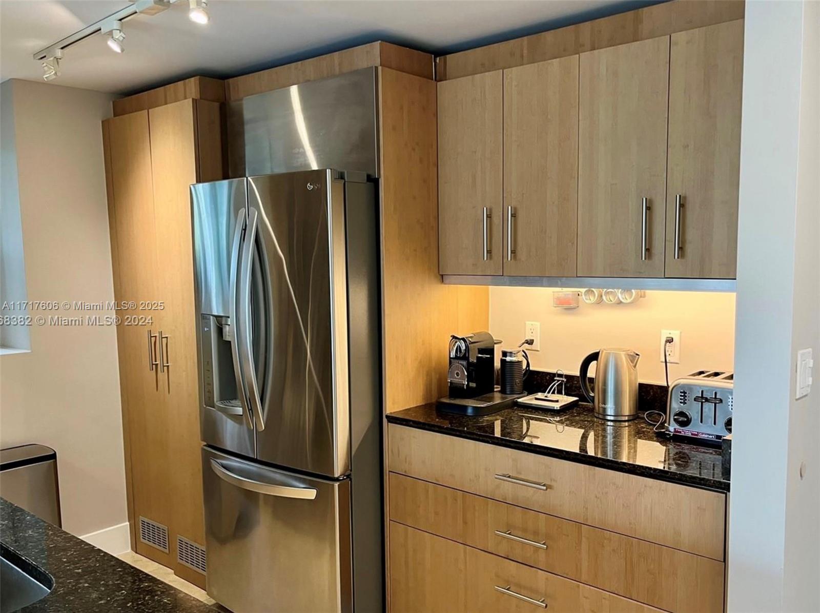 10275 Collins Avenue, Unit 331 Bal Harbour, FL 33154 - Photo 9 of 15 a kitchen with stainless steel appliances granite countertop a refrigerator and a sink