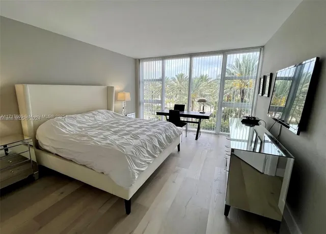 a spacious bedroom with a bed and large windows
