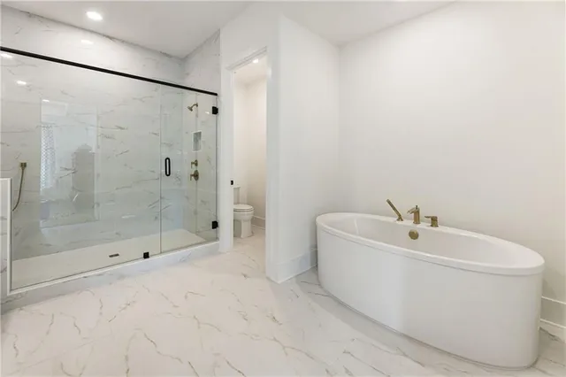 a front view of a residential apartment building with a yard and seating space