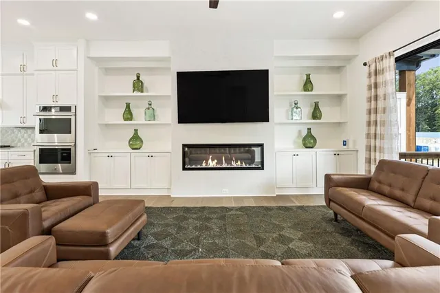 a kitchen with stainless steel appliances granite countertop a stove a refrigerator a sink a dining table and chairs with wooden floor