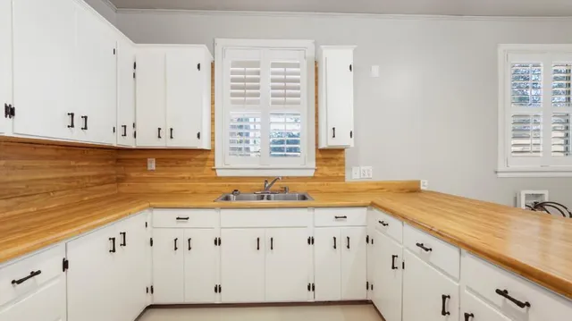 a kitchen with granite countertop white cabinets and sink