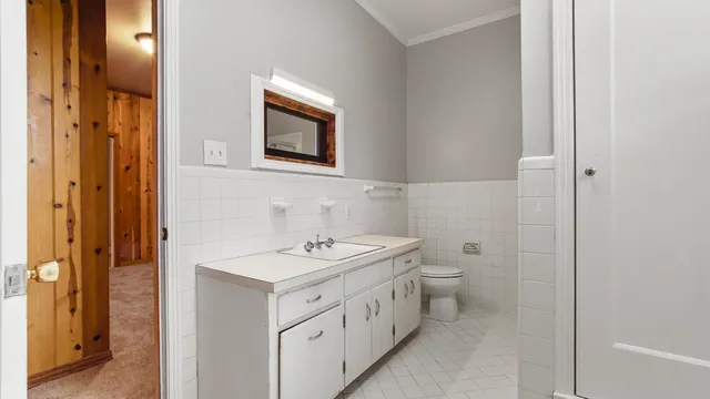 a bathroom with a toilet sink and mirror