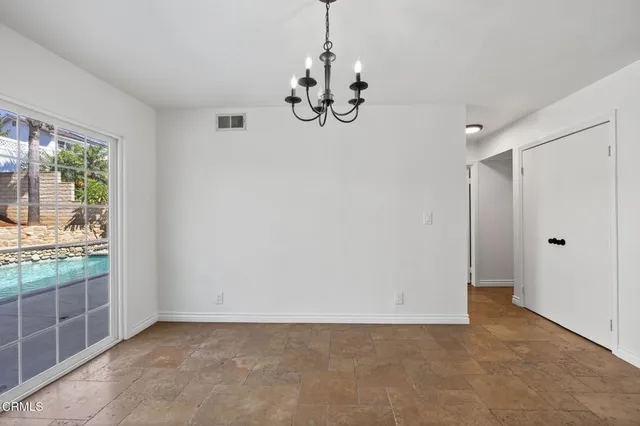 a view of an empty room with window wooden floor and cabinet