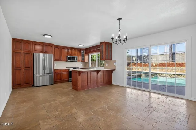 a open kitchen with stainless steel appliances granite countertop a refrigerator and a sink