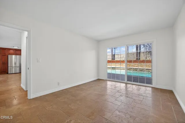 a view of a big room with wooden floor and a kitchen
