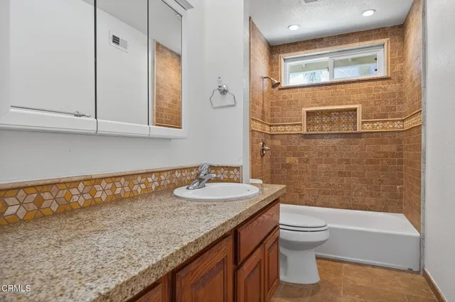 a bathroom with a granite countertop sink toilet and shower