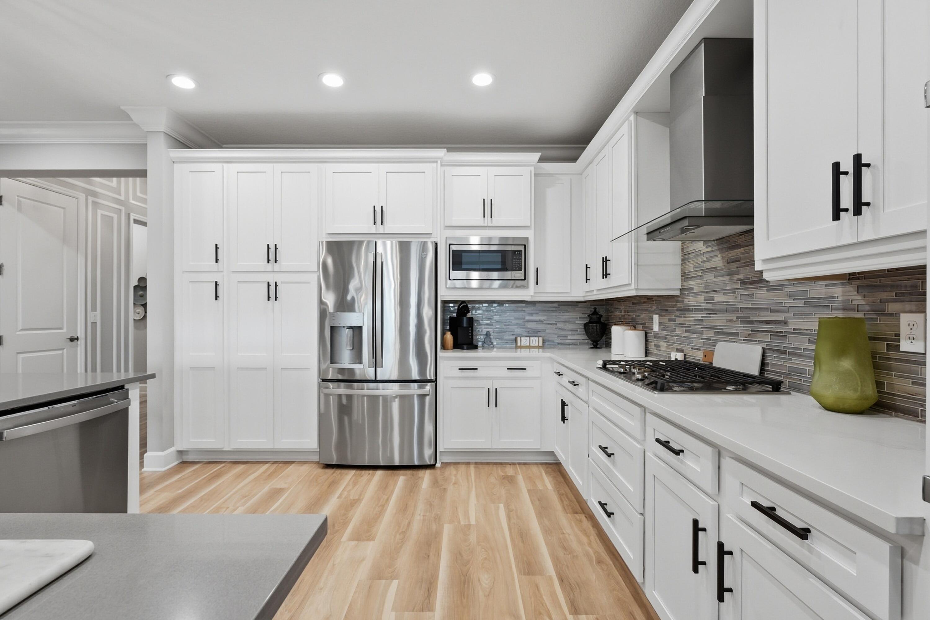 11784 Southwest Sailfish Isles Way Port St. Lucie, FL 34987 - Photo 13 of 77 a kitchen with stainless steel appliances granite countertop a refrigerator sink and cabinets