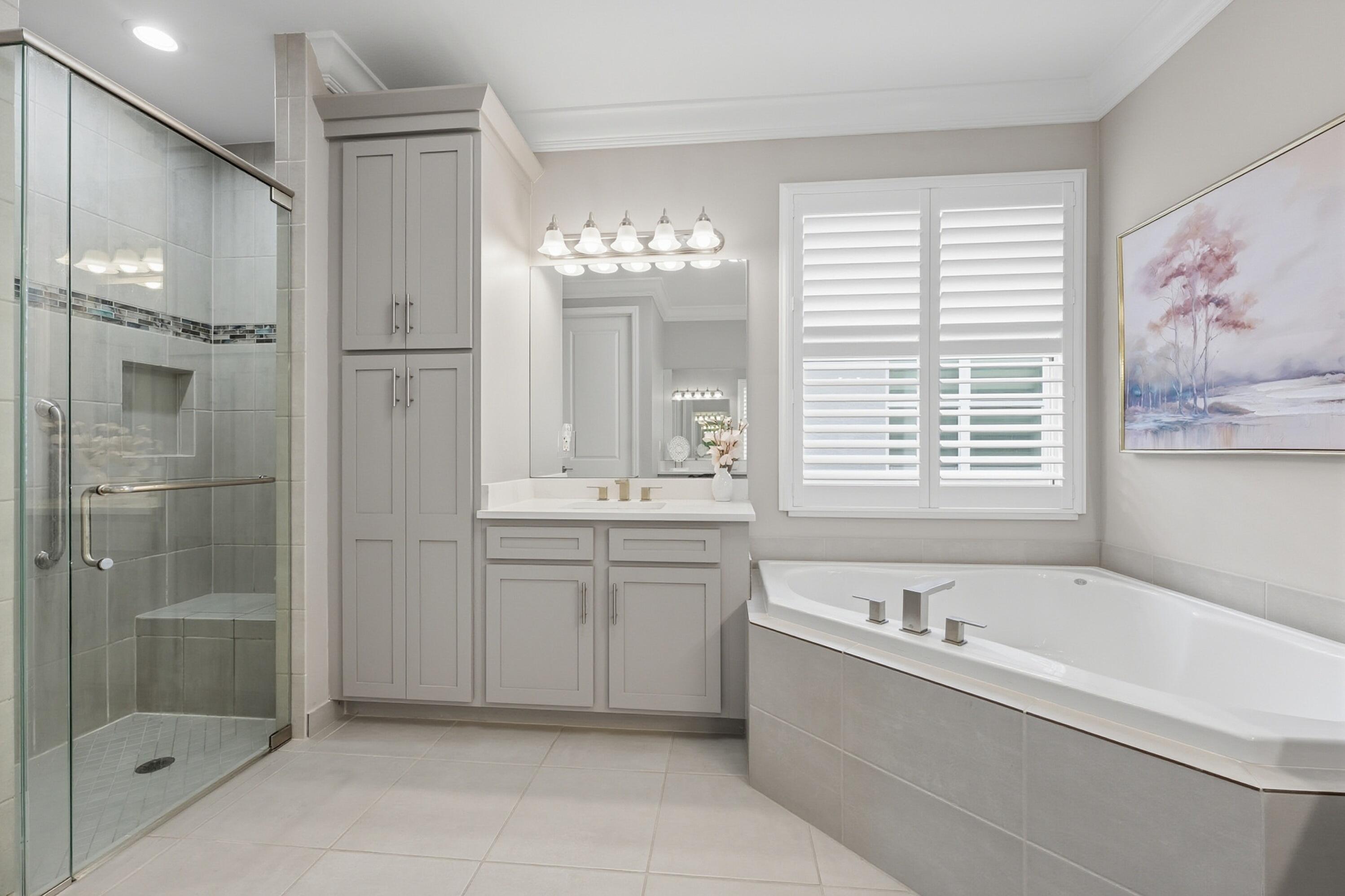 11784 Southwest Sailfish Isles Way Port St. Lucie, FL 34987 - Photo 21 of 77 a bathroom with a tub sink shower and mirror