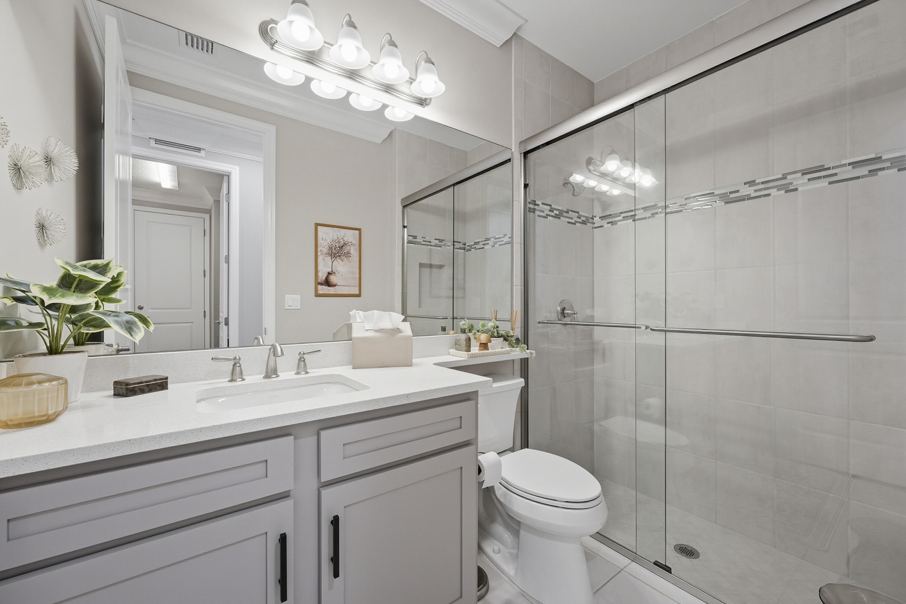 11784 Southwest Sailfish Isles Way Port St. Lucie, FL 34987 - Photo 28 of 77 a bathroom with a sink a toilet a mirror and shower