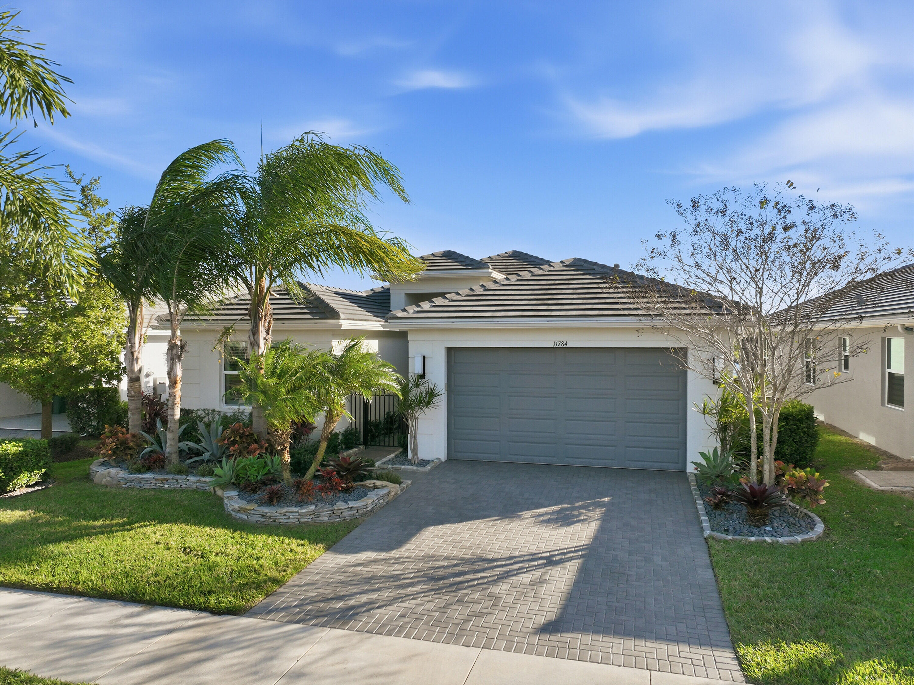 11784 Southwest Sailfish Isles Way Port St. Lucie, FL 34987 - Photo 4 of 77 a front view of a house with a yard and garage