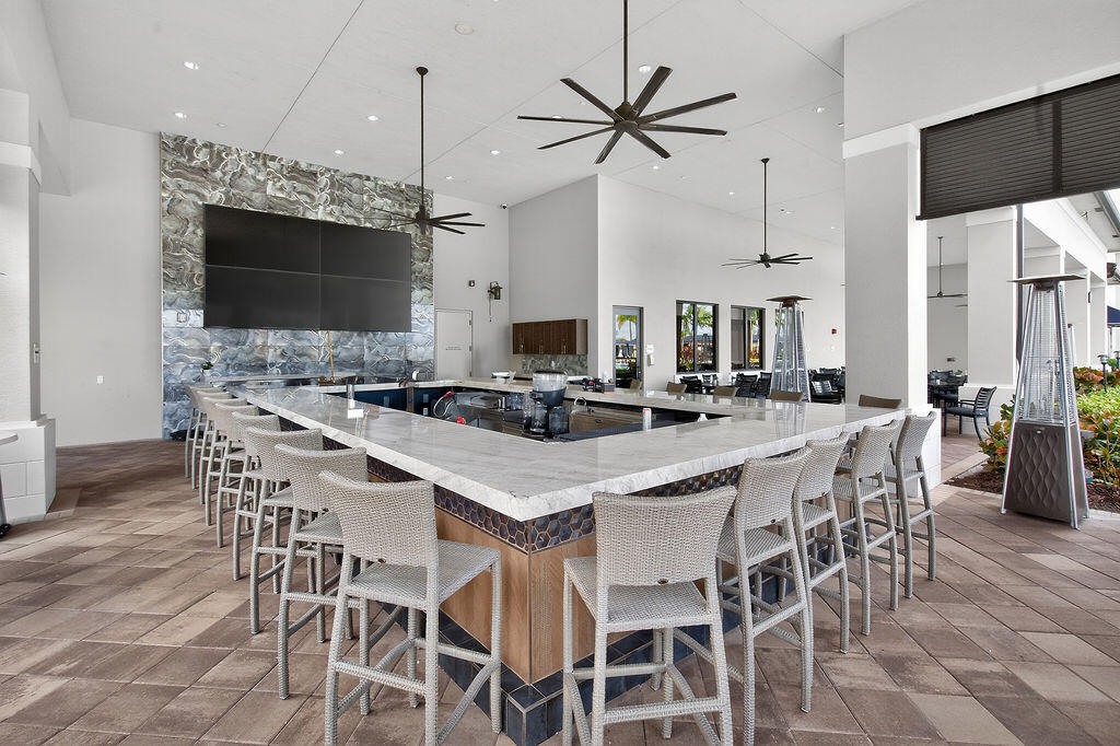 11784 Southwest Sailfish Isles Way Port St. Lucie, FL 34987 - Photo 46 of 77 a kitchen with a dining table chairs and white cabinets