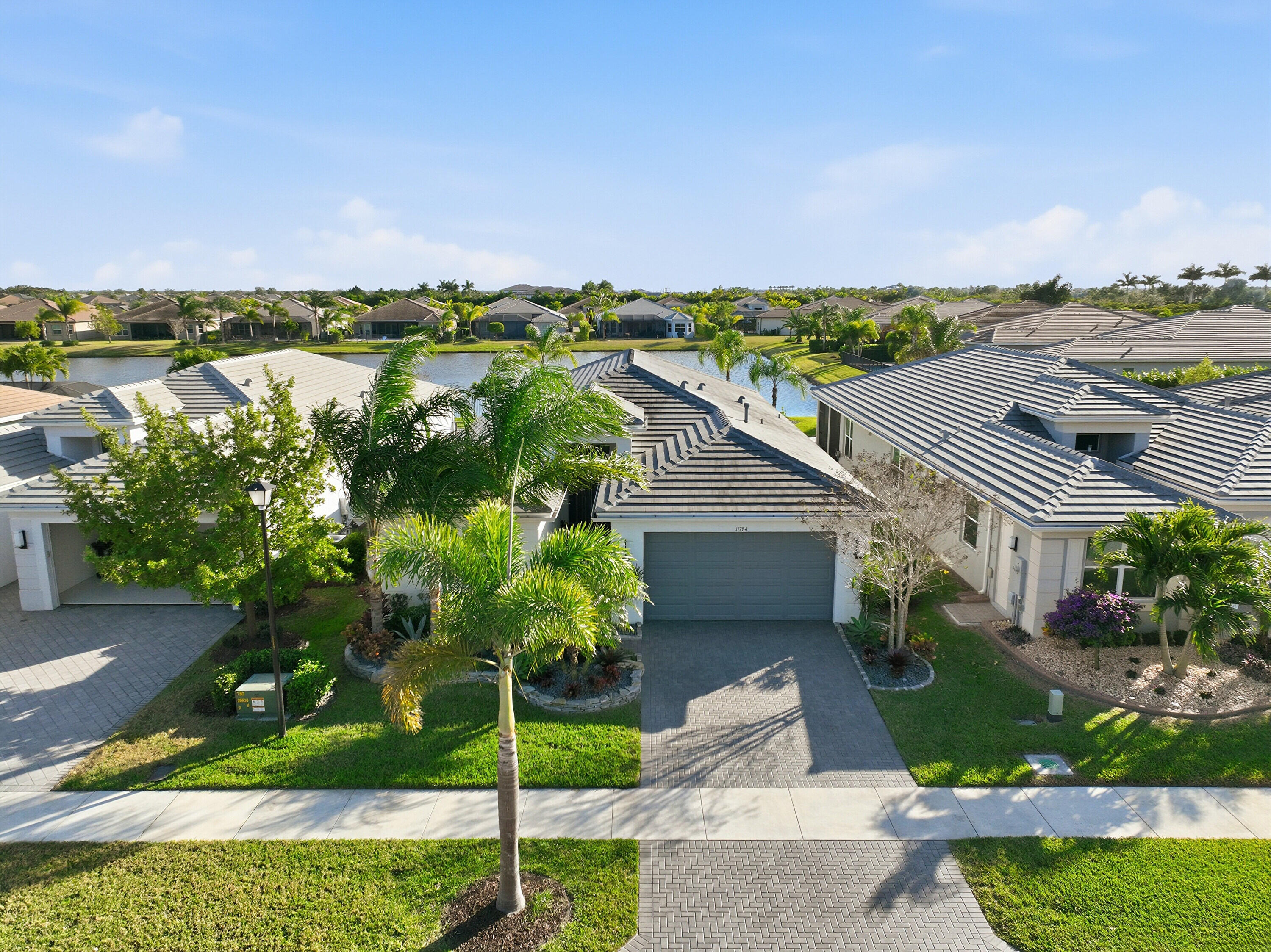 11784 Southwest Sailfish Isles Way Port St. Lucie, FL 34987 - Photo 5 of 77 a view of a house with a yard and potted plants