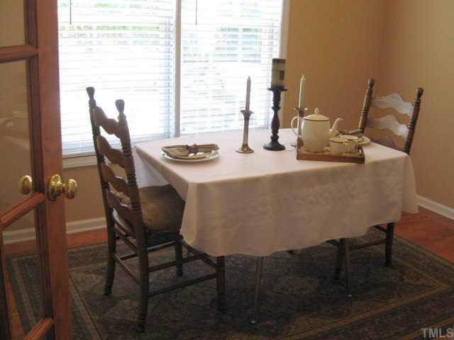 1316 Red Twig Road Apex, NC 27502 - Photo 3 of 12 Beatuiful hardwood flooring and a classic French door enhance the formal dining room which can also be used as an in-home office. There is also access to an under-stair storage area via this room.