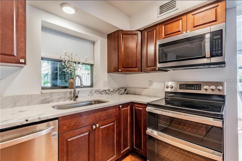 368 Ridge Road Southwest Largo, FL 33770 - Photo 9 of 46 a kitchen with wooden cabinets and a stove top oven