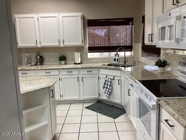a kitchen with stainless steel appliances granite countertop a sink stove refrigerator and cabinets
