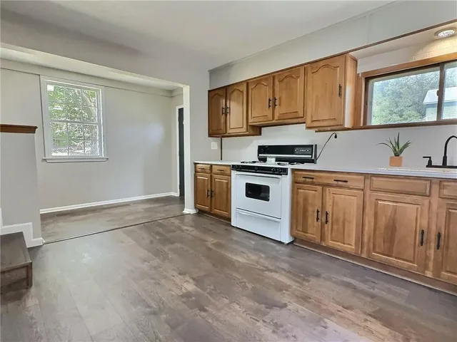 a kitchen with a stove a sink and a window