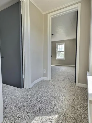 a view of a hallway with wooden floor and front door